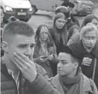  ?? AP ?? Students react as they gather outside the Perm State University in Russia on Monday following a shooting that killed six and injured many others.