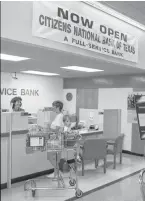  ?? Houston Chronicle file photo ?? A Kroger’s customer with a grocery cart visits with a teller at a Citizens National Bank branch in 1992.