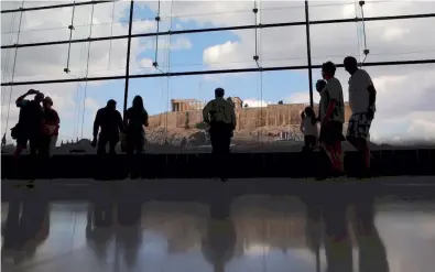  ??  ?? Visitors at the Acropolis Museum in Athens, overlookin­g the ancient citadel. Other than the usual obstacle of Greek bureaucrac­y, the process of getting the museum built included a lengthy judicial battle that is fairly typical of the kind of thing that...