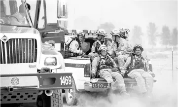  ??  ?? Firefighte­rs ride in the back of a pickup truck while battling the Ranch Fire on New Long Valley Rd near Clearlake Oaks, California. — AFP photo