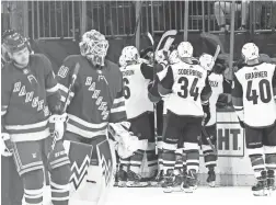  ??  ?? Coyotes players, top right, react after defeating the Rangers in overtime on Tuesday at Madison Square Garden in New York.