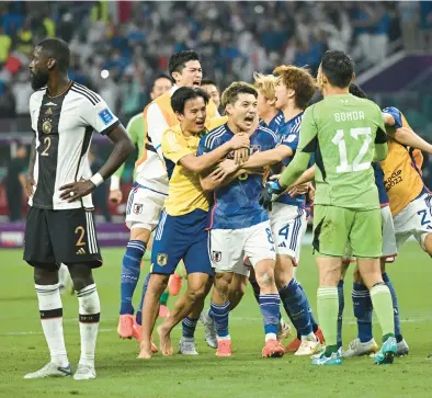  ?? STUART FRANKLIN/GETTY ?? Japan celebrates after beating Germany 2-1 in a Group E match at the World Cup on Wednesday in Doha, Qatar.