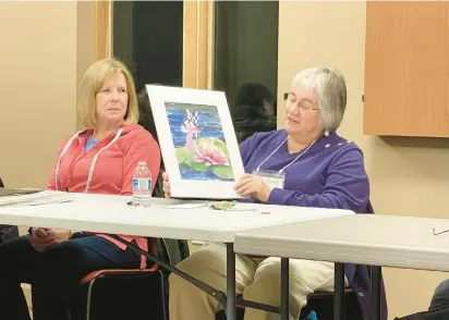  ?? BILL JONES/DAILY SOUTHTOWN ?? Barbara Kelly explains the techniques used on one of her pieces while fellow Lemont Artists Guild member Cheryl Ferber listens during the group’s annual Show and Tell event earlier this month at the Homer Township Public Library.