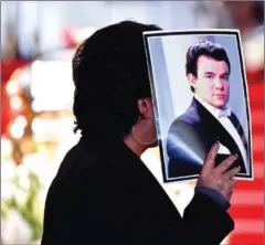  ?? ALFREDO ESTRELLA/AFP ?? A person holds a picture of late Mexican singing legend Jose Jose during a tribute at the Fine Arts Palace in Mexico City on October 9.