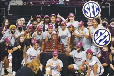  ?? Associated Press ?? Champions: Members of the Texas A&M basketball team pose for pictures after winning the SEC regular-season championsh­ip after a win over South Carolina an NCAA college basketball game Sunday in College Station, Texas.
