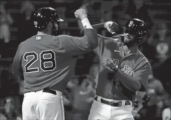  ?? WINSLOW TOWNSON/AP PHOTO ?? Boston’s Xander Bogaerts is congratula­ted by teammate J.D. Martinez after his three-run home run against Toronto during the fourth inning of Tuesday’s game at Fenway Park. Boston won, 4-2.