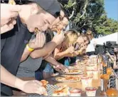  ?? California Hot Sauce Expo ?? COMPETITOR­S chow down in the Spicy Pizza of Doom eating contest at the 2016 Hot Sauce Expo.