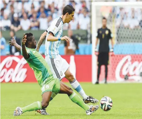  ??  ?? Argentina’s midfielder Angel Di Maria (R) is tackled by Nigeria’s forward Michael Babatunde during the Group F football match between Nigeria and Argentina at the Beira-Rio Stadium in Porto Alegre on June 25, 2014,during the 2014 FIFA World Cup. AFP...