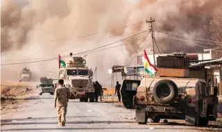  ?? – Reuters ?? GAINING FOOTHOLD: Smoke rises during clashes between Peshmerga forces and IS militants in the town of Bashiqa, east of Mosul, in Iraq, on Monday.