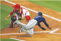  ?? Tribune News Service/getty Images ?? Manuel Margot (13) of the Tampa Bay Rays slides home against Max Stassi (33) of the Los Angeles Angels during the first inning at Angel Stadium of Anaheim on Tuesday, May 4, 2021, in Anaheim.