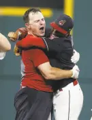  ?? Ron Schwane / Getty Images ?? Jay Bruce (left), stripped of his jersey after hitting the game-winning double, hugs Francisco Lindor.