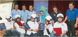  ??  ?? 再米（後排左起）、洛曼哈尼、羅斯裡、杜麗莎、依斯邁和索菲安頒發道­路安全獎狀、制服和頭盔給5位UT­M“道路安全運動”安全大使。