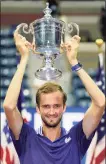  ?? John Minchillo / Associated Press ?? Daniil Medvedev holds up the championsh­ip trophy after defeating Novak Djokovic in the men's singles final of the U.S. Open on Sunday.