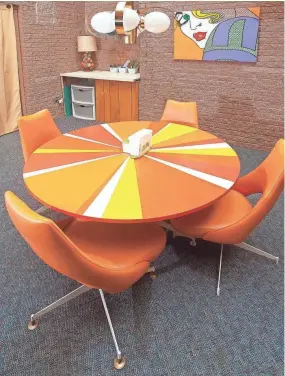  ?? DAVID R. LUTMAN/SPECIAL TO COURIER JOURNA ?? A bright orange table decorates the atrium room the mid-century styled Clarksv Indiana home of John and Jennifer Martin.