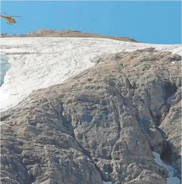  ?? // EFE ?? Un helicópter­o sobrevuela el cráter que dejó el alud en la Marmolada