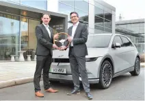  ?? Courtesy of Hyundai Motor Group ?? UK Car of the Year Awards Editor and Managing Director John Challen, left, and Hyundai Motor UK Managing Director Ashley Andrew pose in front of the award-winning IONIQ 5, Tuesday.