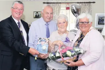  ??  ?? Royal seal of approval The happy couple received a card from the Queen and are pictured being congratula­ted on their anniversar­y by North Lanarkshir­e provost Jean Jones and depute lieutenant Louis Munn