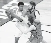  ?? AJ MAST/AP ?? Kansas’ David McCormack, left, is pressured by Eastern Washington’s Tanner Groves, right, and Jacob Groves on Saturday.