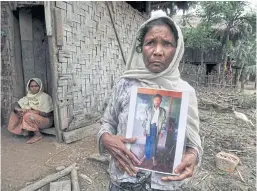  ??  ?? FAMILY GRIEF: Moeyeyan Khatu holds a photograph of her son Atthu Suwan, who was stabbed and taken from his home on July 4.