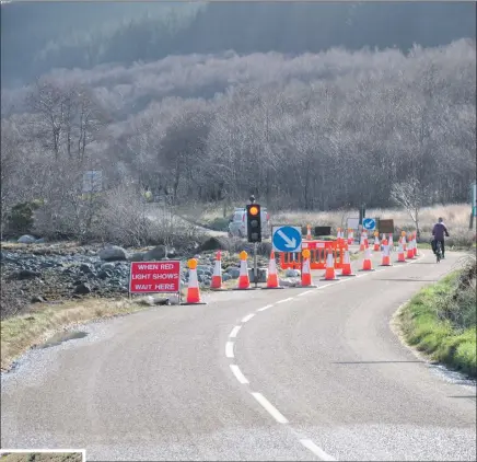  ??  ?? Above: temporary traffic lights north of Corrie after the coast road was damaged and, left, the landslide near the North Sannox car park.