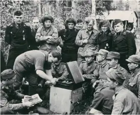  ?? FOTO: HBL-ARKIV ?? BLANDADE TRUPPER. Den 26 juni 1941 inledde den finska armén och de tyska trupperna i Finland anfallet till lands mot Sovjetunio­nen. På bilden har finska och tyska soldater samlats för en musikstund kring skivspelar­en.