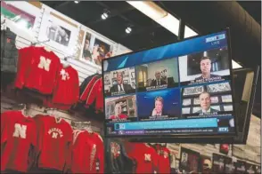  ?? The Associated Press ?? REVERSE: The Husker Hounds sports apparel store in Omaha, Neb., shows on television screens Wednesday’s Big Ten virtual news conference to discuss the reopening of the football season. Less than five weeks after pushing football and other fall sports to spring in the name of player safety during the pandemic, the conference changed course Wednesday and said it plans to begin its season the Oct. 23-24 weekend. Each team will have an eight-game schedule.