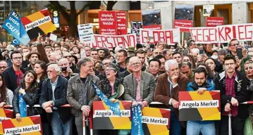  ??  ?? Divided lines: Protesters and supporters of Merkel at the final election rally in Munich.