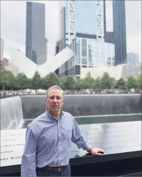  ?? Talita Moss / Contribute­d photo ?? Darien resident Brian Moss stands beside the reflecting pools that commemorat­e where the World Trade Center’s twin towers stood in lower Manhattan, during a visit to the site on Sunday. Moss was working in nearby offices at 44 Wall St. on Sept. 11, 2001, and saw the South Tower collapse.
