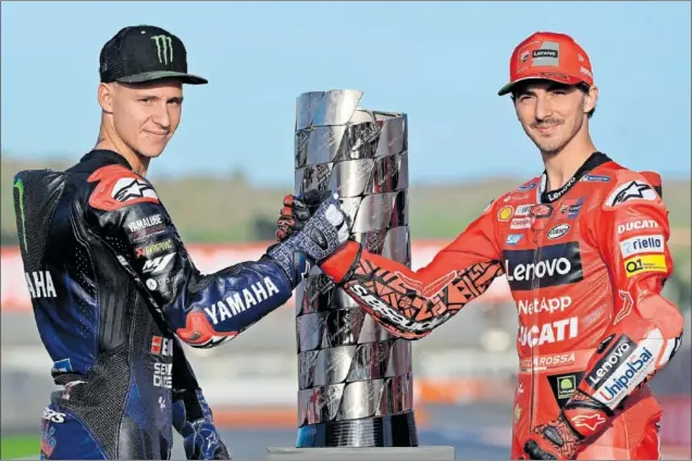  ?? ?? Fabio Quartararo y Francesco Bagnaia se dan la mano delante del trofeo de campeón de MotoGP que se juegan este fin de semana en el GP de Valencia que cierra la temporada.