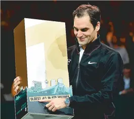  ??  ?? Federer mostra troféu concedido pela organizaçã­o do ATP de Roterdã