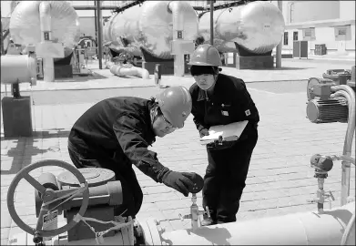  ?? XINHUA ?? China National Petroleum Corp technical employees check facilities at Qinghai oilfield.