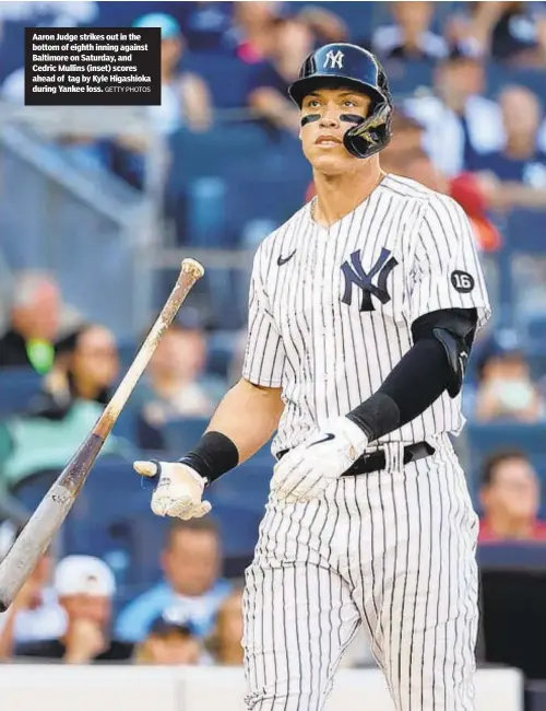  ?? GETTY PHOTOS ?? Aaron Judge strikes out in the bottom of eighth inning against Baltimore on Saturday, and Cedric Mullins (inset) scores ahead of tag by Kyle Higashioka during Yankee loss.