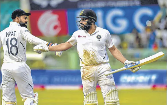  ?? AFP PHOTO ?? India captain Virat Kohli (left) congratula­tes Rohit Sharma after the opener was dismissed for 127 on Sunday in Visakhapat­nam.