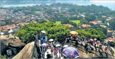  ?? YAN DAMING / FOR CHINA DAILY ?? Tourists take in a panoramic view of the Gulangyu area in Siming district, Xiamen, from Riguangyan, a popular scenic spot.