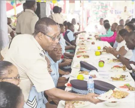  ?? (Department of Public Informatio­n photo) ?? Assistant Police Commission­er Clifton Hicken serving junior ranks at ‘A’ Division’s second annual Christmas luncheon and awards ceremony yesterday.