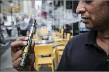  ?? BEBETO MATTHEWS — THE ASSOCIATED PRESS ?? Inam Rehman, manager of Jubilee Vape & Smoke Inc., vapes Monday while discussing New York Gov. Andrew Cuomo’s push to enact a statewide ban on the sale of flavored e-cigarettes amid growing health concerns in New York.