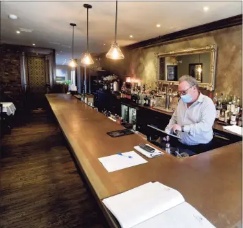  ?? H John Voorhees III / Hearst Connecticu­t Media ?? Manager Roberto Moro behind the bar at La Zingara Ristorante in Bethel. Because of COVID-19 space restrictio­ns, La Zingara has no seating at the bar. Gov. Ned Lamont announced plans to ease rules.