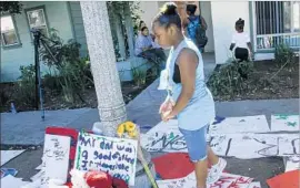  ??  ?? RAQUEL THOMAS, 9, pays her respects to her father. After protesters marched Friday night, Pasadena police released security video and audio from a 911 call.