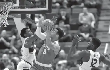  ?? JOHN WOIKE/TRIBUNE NEWS SERVICE ?? Connecticu­t Huskies guard Christian Vital (1) defends Boston University Terriers guard Eric Fanning (3) as he drives to the hoop at the XL Center in Hartford Wednesday night in Hartford, Conn. College roundup