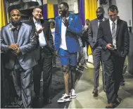  ?? Gabrielle Lurie / The Chronicle ?? Draymond Green (center) walks through Oracle Arena in his Rich Fresh short suit after game 2 of the NBA Finals.NEW GUARD NBA UNIFORM: It was the NBA fashion sensation seen ’round the world, and the ultimate victor at this year’s NBA Finals (along with our Golden State Warriors). Then-Cleveland Cavalier LeBron James started the runway-to-court moment when he outfitted his teammates in Thom Browne suiting for the championsh­ip games. King James was the only one of his teammates brave enough to don Browne’s short suit, the designer’s longtime menswear signature, for the pregame walks and postgame press conference­s. Coninciden­tally, Golden State Warrior Draymond Green already had a short suit look in the works from bespoke Los Angeles tailor Rich Fresh for game 2: In Carribean blue with wide piped lapels and tuxedo striping. At the conference following the Warriors’ victory in game 2, Green noted that he had already worn short suiting publically a year before James collaborat­ed with Browne. What better way to show off those designer sneakers?— Tony Bravo