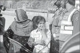  ?? AP/MUHAMMAD SAJJAD ?? Relatives of officials trapped inside an agricultur­al research complex in Peshawar in northwest Pakistan wait at a police line Friday while police and soldiers battle Islamist militants who stormed the institutio­n.