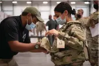  ?? The Associated Press ?? In this image provided by the U.S. Army, Sgt. Katiushka Rivera, a soldier assigned to the 82nd Airborne, gets fitted for a modular scalable vest (MSV) during a fielding event in Fort Bragg, N.C., on Sept. 13. The Army began handing out armor that now comes in three additional sizes, and can be adjusted in multiple ways to fit better and allow soldiers to move faster and more freely.