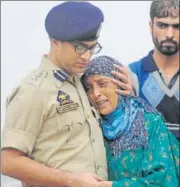  ?? WASEEM ANDRABI/HT ?? ▪ A police officer comforts the wife of slain policeman Habibullah who died in Srinagar on Friday. Habibullah was critically injured in a militant attack a week ago.