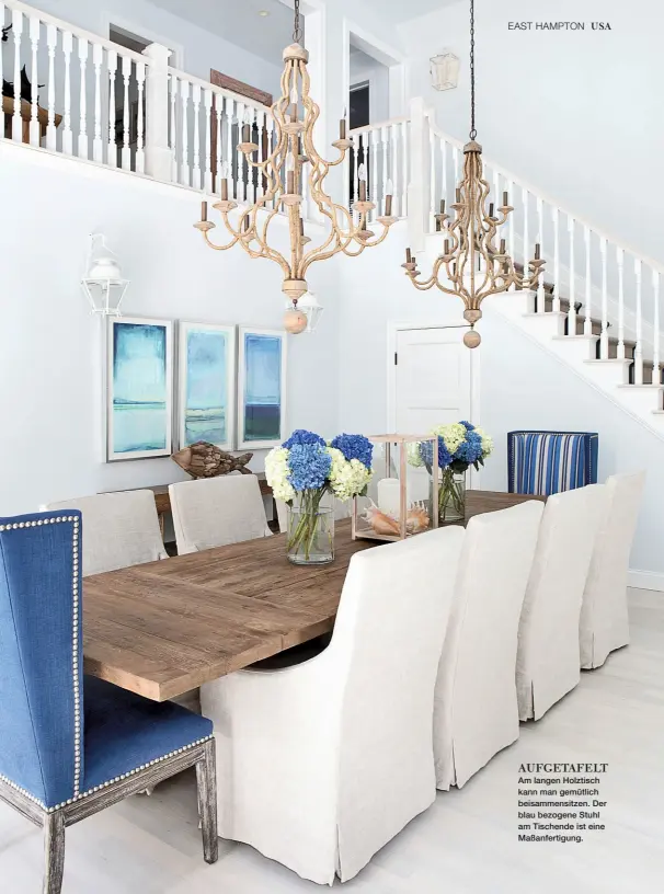  ??  ?? AUFGETAFEL­T Am langen Holztisch kann man gemütlich beisammens­itzen. Der blau bezogene Stuhl am Tischende ist eine Maßanferti­gung.