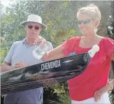  ??  ?? Master rowers Brent Rolfe, left, and Maureen Kelly christen a shell during a ceremony at Niagara Falls Rowing Club.