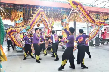  ??  ?? A dragon dance troupe performs in front of the Tua Pek Kong Temple.