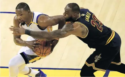  ?? EZRA SHAW/GETTY IMAGES ?? Kevin Durant of the Golden State Warriors, left, works against defender LeBron James of the Cleveland Cavaliers during Game 1 of the NBA Finals Thursday in Oakland. Durant had 38 points in the Warriors’ 113-90 victory, forcing a shift in defensive...