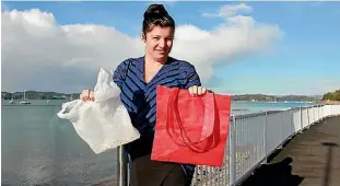  ?? BAYLEY MOOR/STUFF ?? Boomerang Bags Paihia project driver Sarah Greener with an ideal reusable bag and a pesky plastic bag.