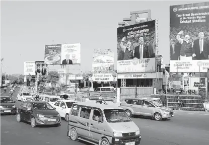  ?? AJIT SOLANKI AP ?? Vehicles drive past billboards welcoming U.S. President Donald Trump in Ahmedabad, India, on Saturday. Trump is visiting the city of Ahmedabad in Gujarat during a two-day trip to India.