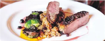  ?? ANDREW HILTZ ?? Harvest Eatery’s duck breast on farro risotto with brussels sprouts, winter squash and raisins,